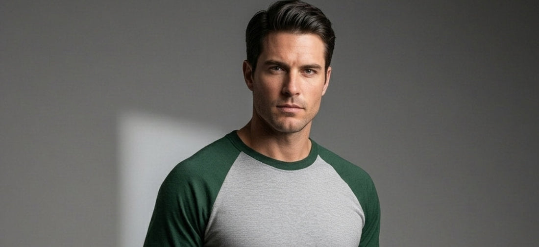 Man wearing a green and gray raglan T-shirt against a studio background